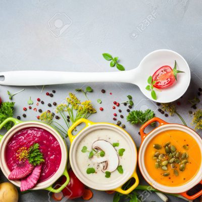 Variety of colorful vegetables cream soups and ingredients for soup. Top view. Concept of healthy eating or vegetarian food.